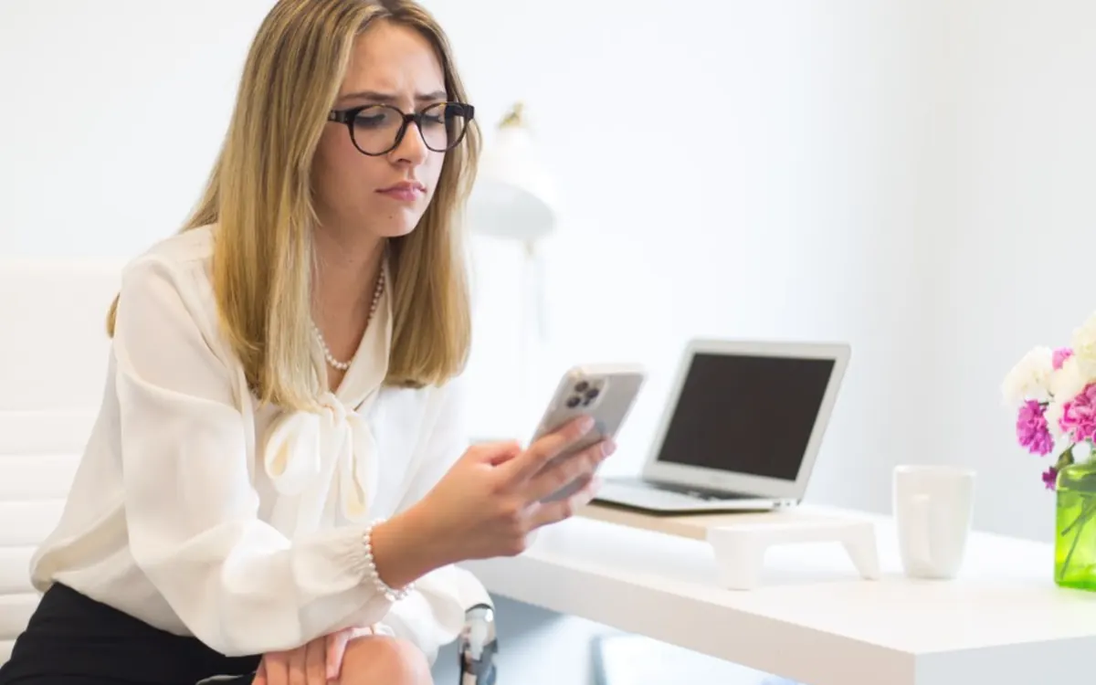 Woman using her phone at a desk